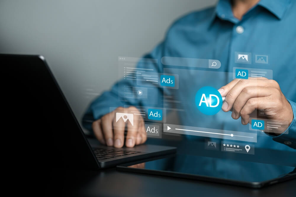 Imagem de um homem utilizando o notebook. Na tela, é possível ver que ele está realizando campanhas de anúncio segmentadas.