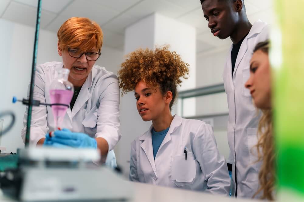 Imagem de professores e universitários se dedicando à pesquisa científica.