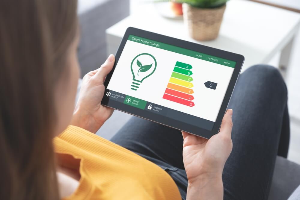 Imagem de uma mulher usando um tablet e verificando o uso de energia solar.