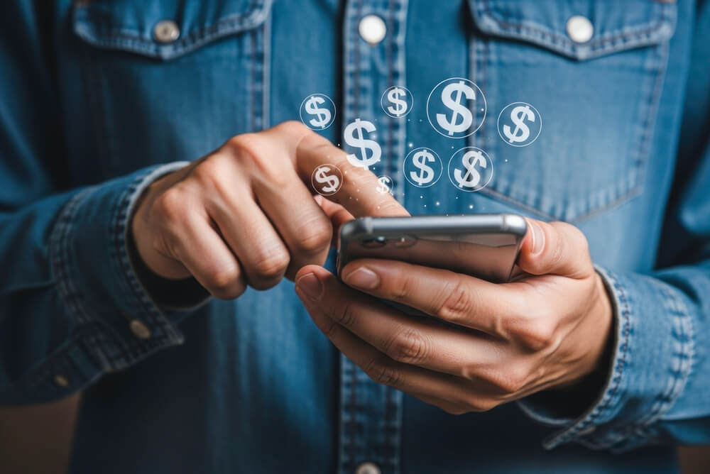 Imagem de uma pessoa mexendo no celular, aparentemente um homem. Ele acaba de receber dinheiro, um depósito do Crédito do Trabalhador.