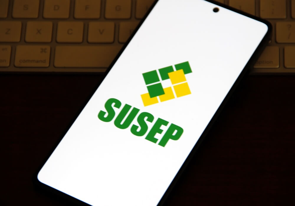 Imagem de um celular. Na tela, é possível ver a logo da Susep.